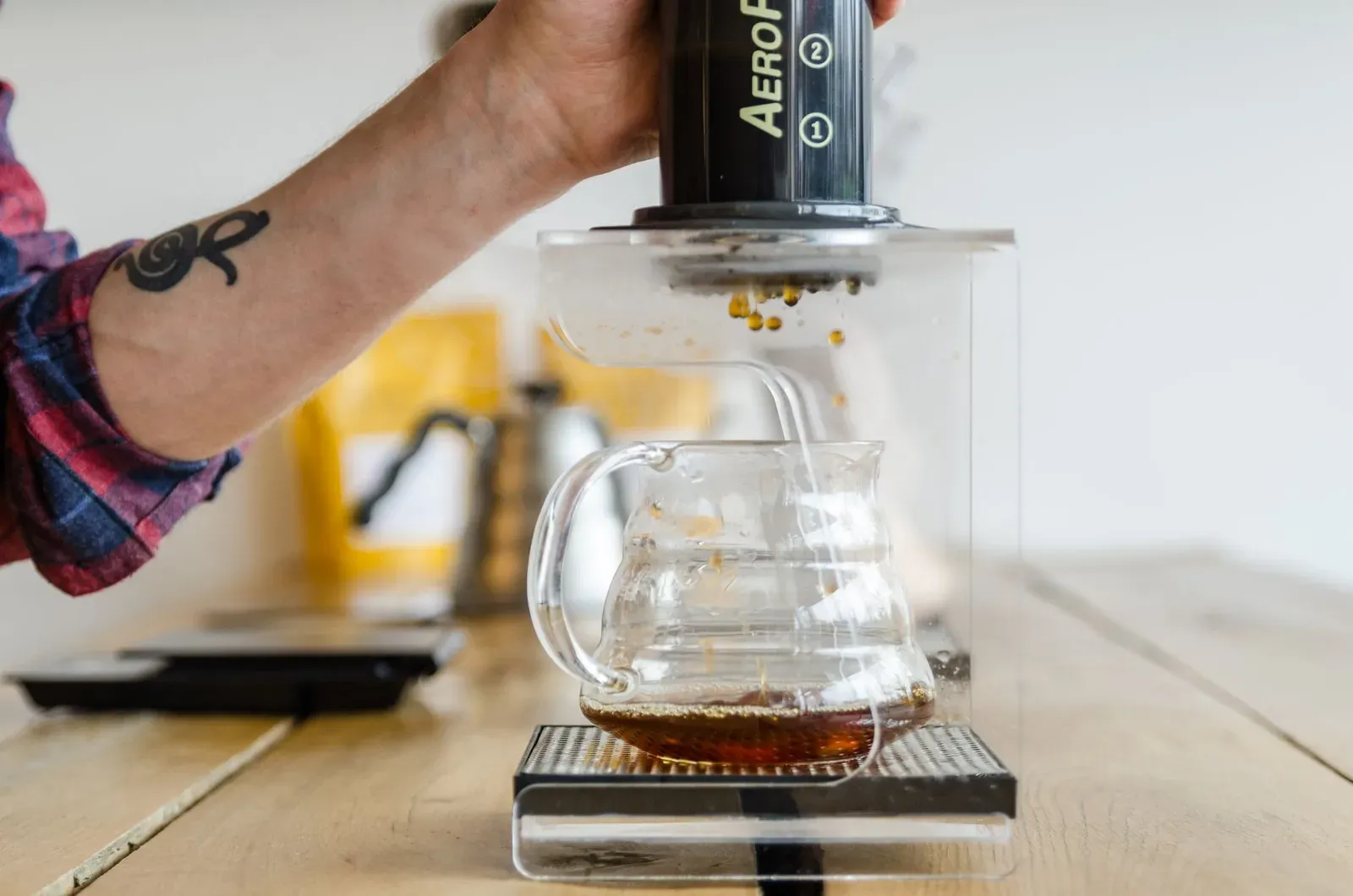 Un AeroPress pressé au-dessus d'une carafe en verre posée sur une balance