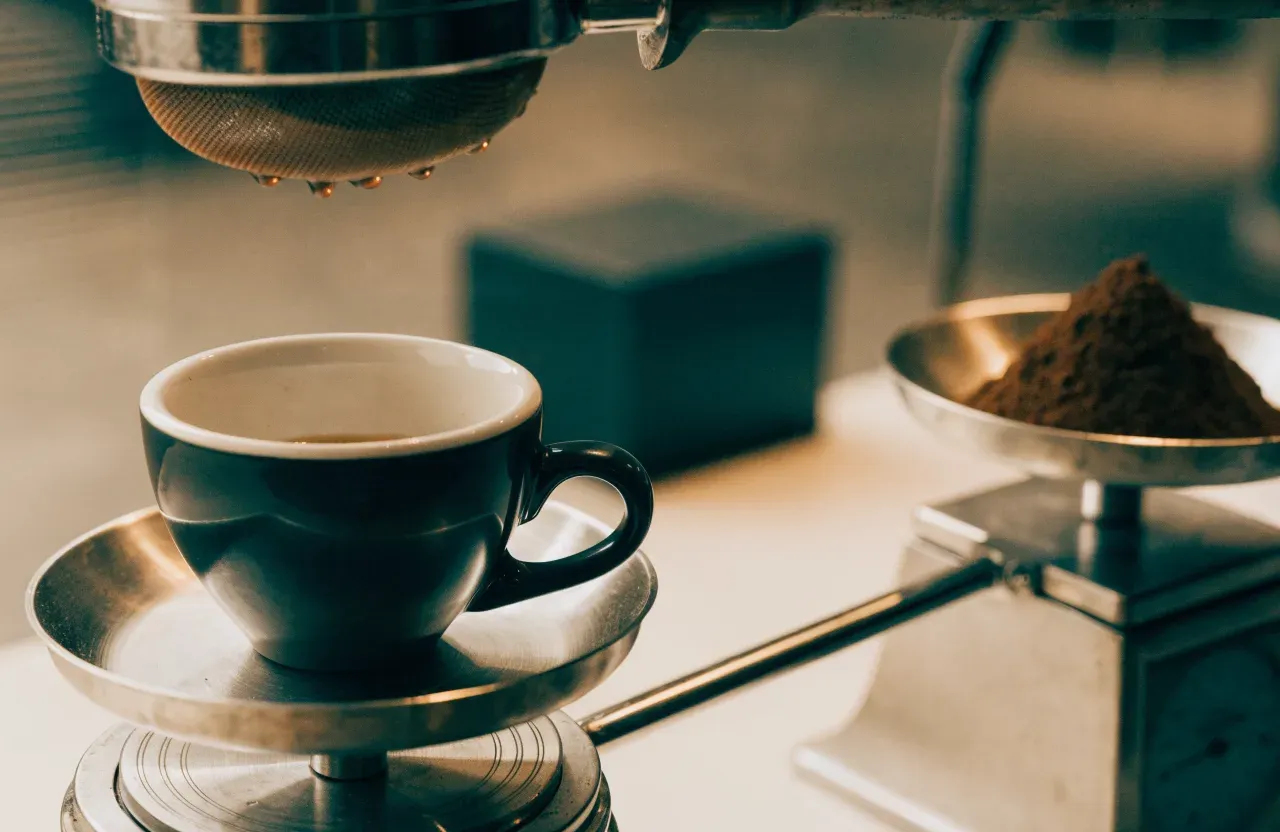 Une balance sous une tasse en verre affichant le poids d'un espresso en fin d'écoulement