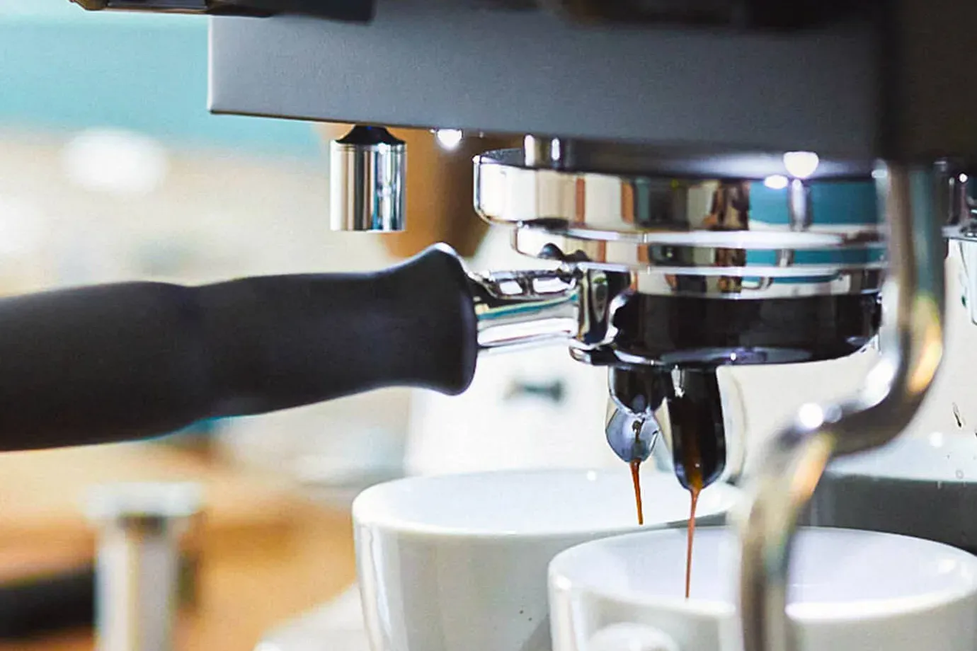 Un espresso double coule d'un porte-filtre à becs dans deux tasses