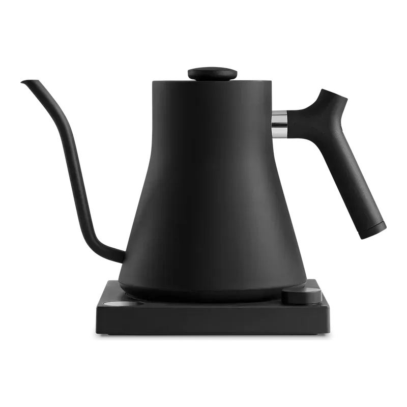 Fellow Stagg EKG gooseneck kettle in matte black on its base, seen from the side