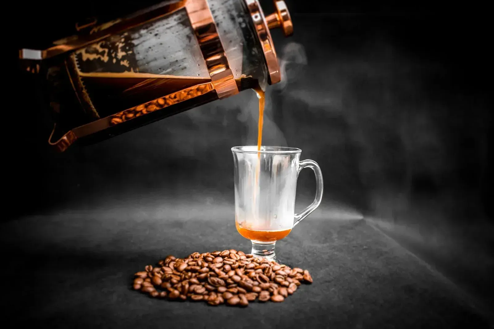 Du café versé d'une cafetière à piston dans un verre