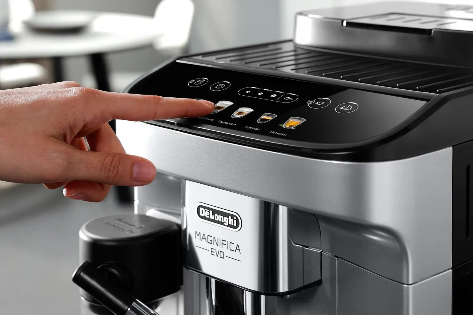 Un doigt qui choisit une boisson sur le panneau tactile d'une machine à grain De'Longhi Magnifica Evo