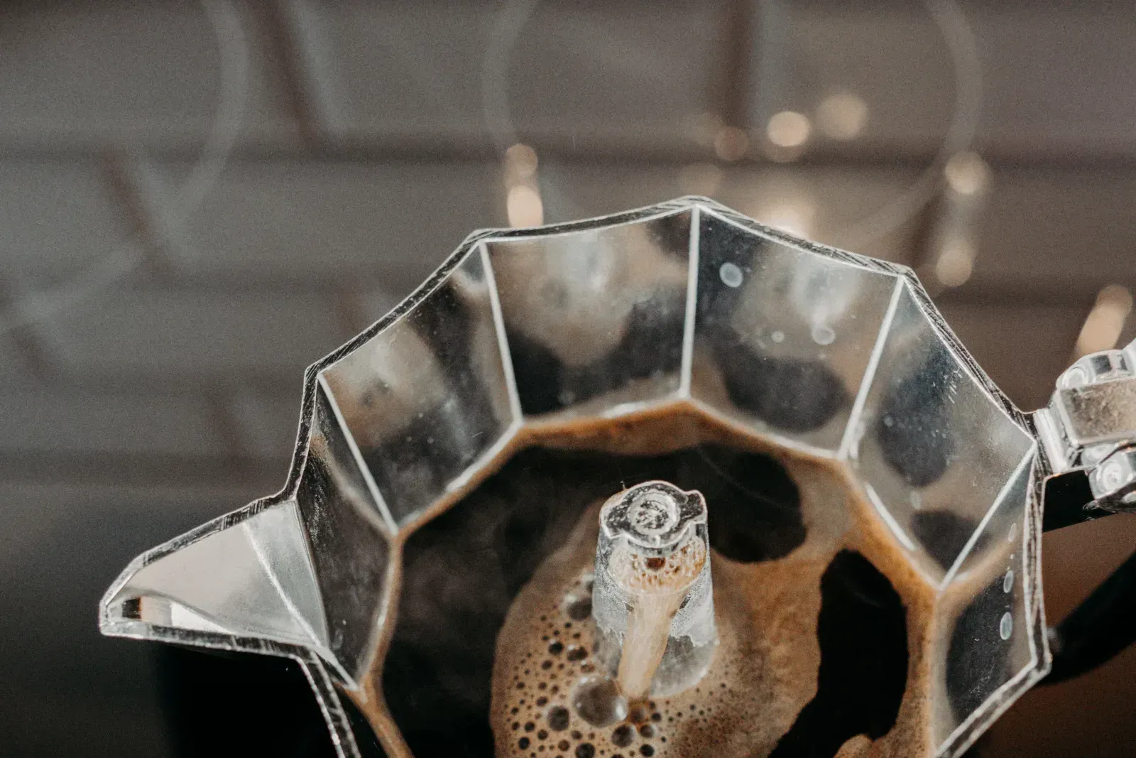 Le café qui monte dans la colonne d'une cafetière moka ouverte sur le feu