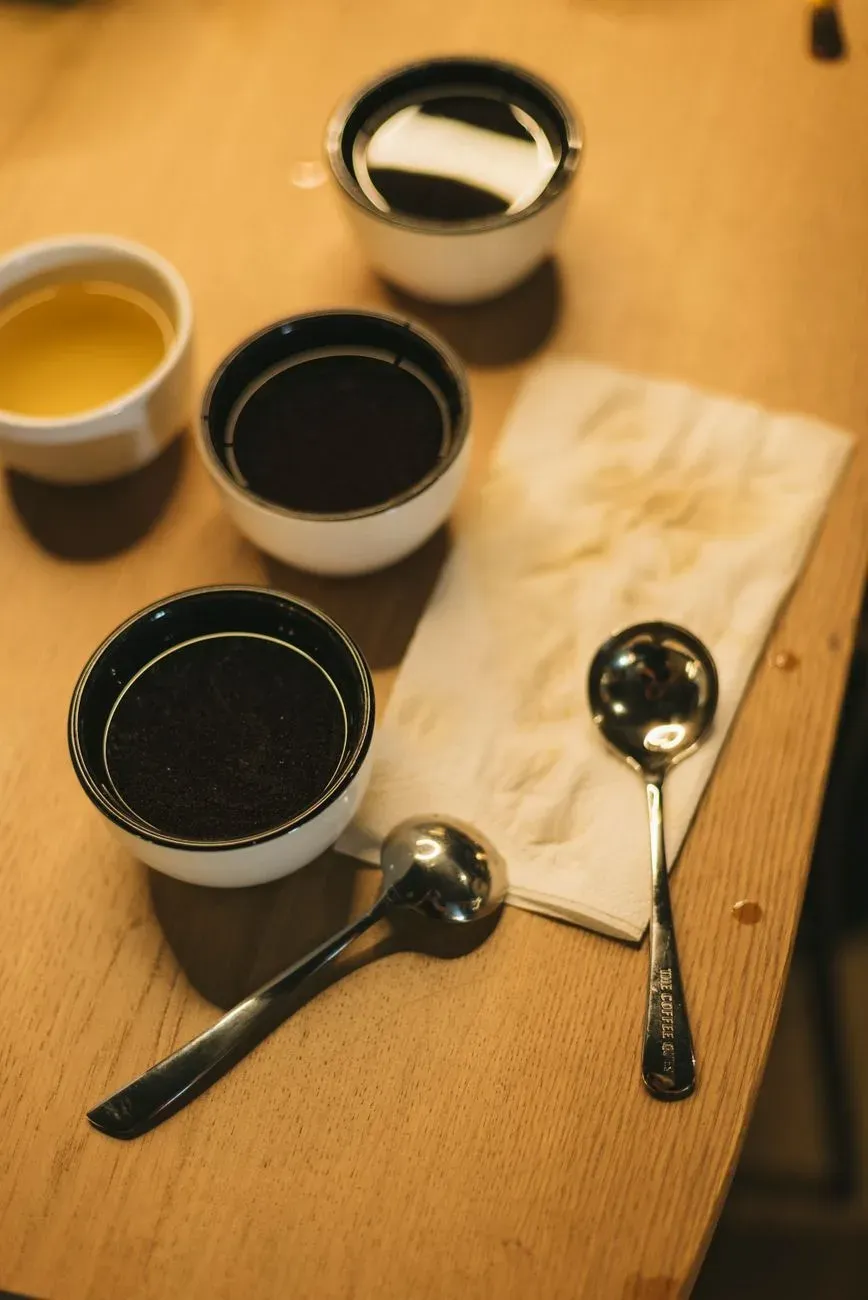 Une table de cupping dressée avec ses bols de dégustation et ses cuillères
