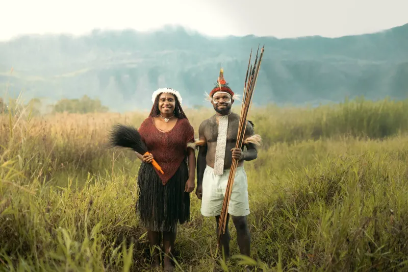 Prairie d'altitude et montagnes de Papouasie-Nouvelle-Guinée avec deux personnes en tenue traditionnelle