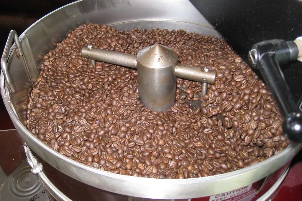 Une fournée de café tout juste torréfié brassée dans le bac de refroidissement d'un petit torréfacteur